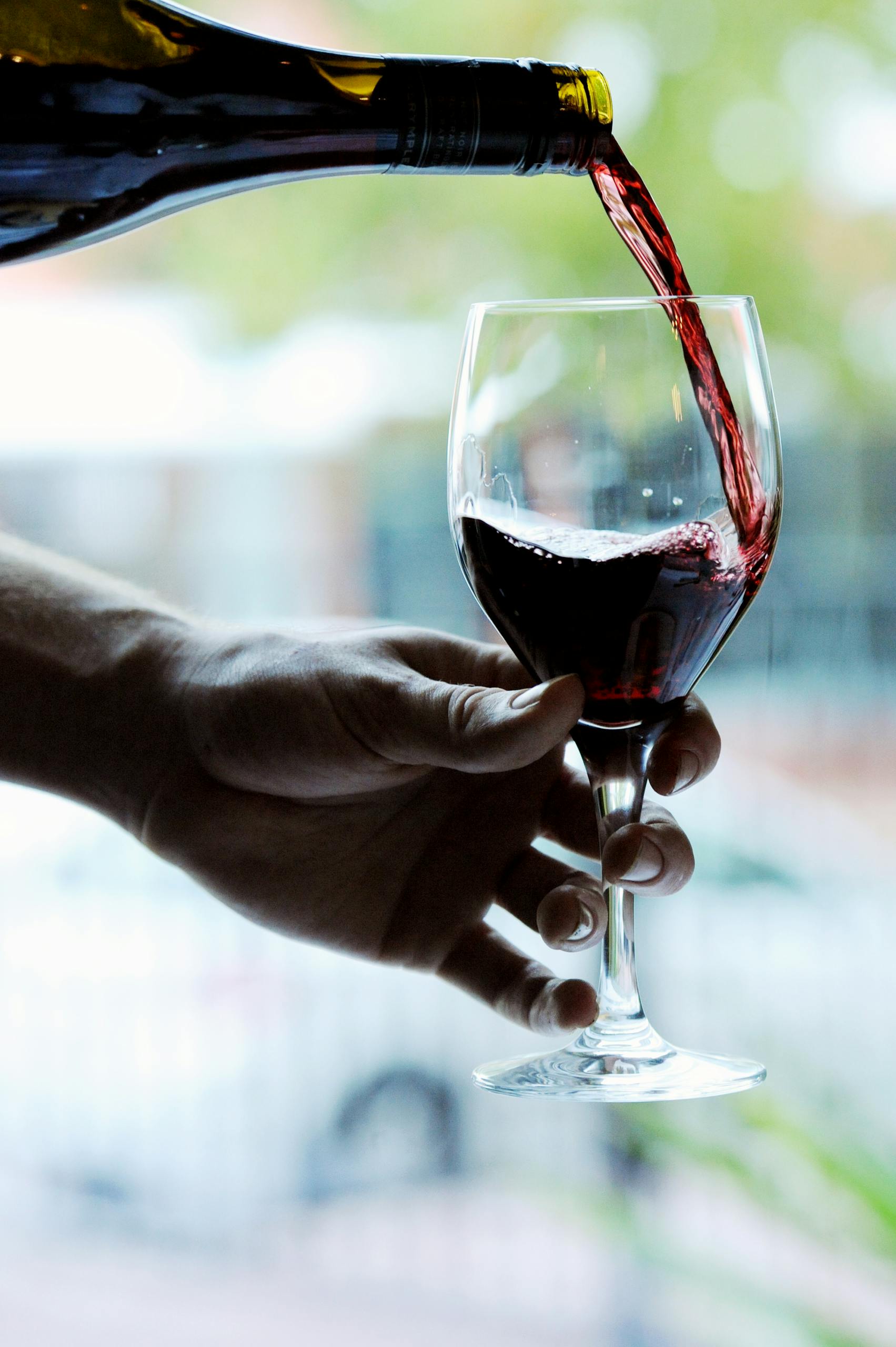 Close-up of red wine being poured into a glass.